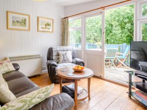 a living room with a tv and a table at 2 Bed in Bideford 78252 in Parkham