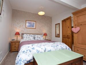 a bedroom with a bed and a table in it at 2 Bed in Bideford 78252 in Parkham