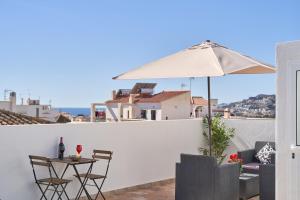 Un patio con una sombrilla y una mesa y sillas. en Nerja Boutique 103 Sweet Corner, en Nerja