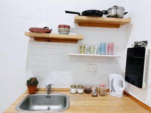 eine Küchentheke mit einer Spüle und einer Mikrowelle in der Unterkunft San Francisco Studios Valletta in Floriana