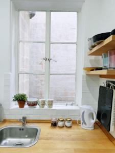 a kitchen counter with a sink and a window at San Francisco Studios Valletta in Il-Furjana