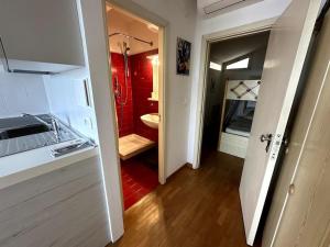 uma cozinha com um lavatório e uma casa de banho vermelha em [Bilocale Frontemare] magnifica terrazza em Alassio