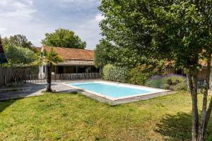 a swimming pool in the yard of a house at À 400m de la plage, maison pour 12 avec piscine in Andernos-les-Bains