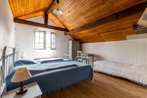 a bedroom with two beds and a wooden ceiling at À 400m de la plage, maison pour 12 avec piscine in Andernos-les-Bains +33 photos