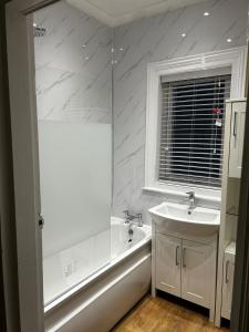 a bathroom with a tub and a sink and a bath tub at The Green House 3 Bed House - Contractors, Families, Free Parking, close to racecourse and city centre in Doncaster