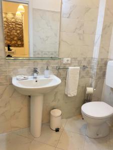 a bathroom with a sink and a toilet and a mirror at B&B Evelyne in Taormina