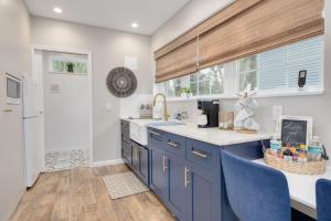 a kitchen with blue cabinets and blue chairs at SHELLY - Cozy 1 bedroom tiny home with pool in Dunedin