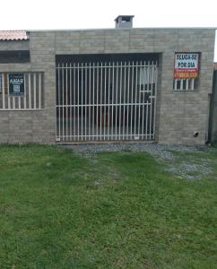 a gate in a brick building with a for sale sign at casa de praia in Guaratuba