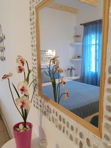 a mirror on a wall next to a bedroom at PERIVOLI 4-CHORA(5min away from the center by car) in Agkidia