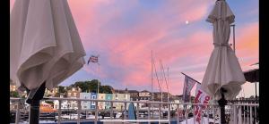 two white umbrellas on a balcony with a marina at Lantana Guest House in Weymouth