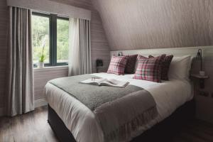 een slaapkamer met een bed met twee boeken erop bij Ardlui Retreat Lodge 2 in Arrochar