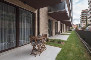 a patio with a wooden table and bench on a balcony at Intimate Ground-Floor Hideaway - 011 in Budapest