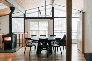 a dining room with a table and chairs and a stove at Alpine Lake House - Waterfront on Lake Muskoka in Port Carling