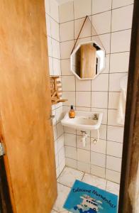 ein kleines Bad mit einem Waschbecken und einem Spiegel in der Unterkunft Espaço Jardim Secreto Hostel in João Pessoa
