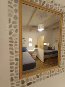 espejo que refleja un dormitorio con cama en una habitación en PERIVOLI 1-CHORA(5min away from the center by car), en Agkidia