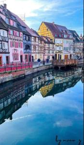 a group of colorful buildings next to a body of water at Gîte chez EsTé in Mittelwihr +19 photos