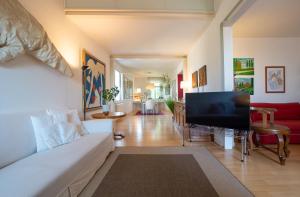 Una sala de estar con un sofá blanco y un televisor de pantalla plana. en Al Cassero, en Perugia