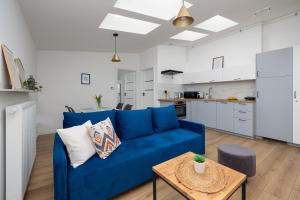 a living room with a blue couch and a table at Plac Grunwaldzki Happy Apartment in Szczecin