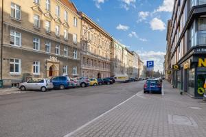 a city street with cars parked on the side of the road at Plac Grunwaldzki Happy Apartment in Szczecin