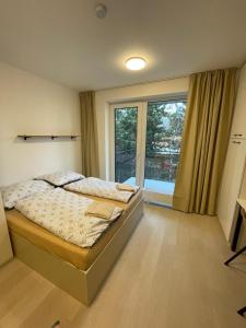 a bedroom with a bed and a large window at Garden apartment Brno center in Brno