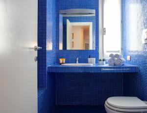 Un baño con azulejos azules, inodoro y lavabo. en Al Cassero, en Perugia 24 fotos más