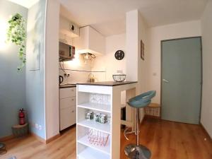 eine Küche mit einer Theke und einem Stuhl in einem Zimmer in der Unterkunft Studio cosy au cœur de Nîmes. in Nîmes