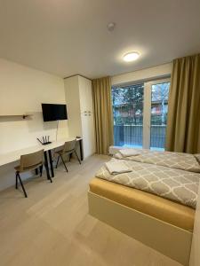 a bedroom with a bed and a desk with a computer at Garden apartment Brno center in Brno