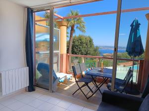 a balcony with a table and a view of the ocean at Magnifique vue mer et piscine - Les Clés de L Estérel in Théoule-sur-Mer