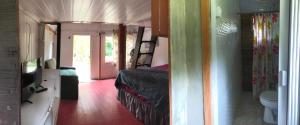 a room with a bed and a bathroom with a toilet at Chalé Sul da Ilha in Ilha do Mel
