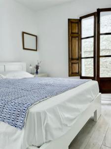 ein Schlafzimmer mit einem Bett mit einer blau-weißen Decke in der Unterkunft Casa Blanca, Acequias, Lecrin valley, Granada in Granada + 103 Fotos