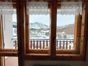 uma janela num quarto com vista para uma montanha em [Prato Nevoso] Appartamento fronte conca em Prato Nevoso