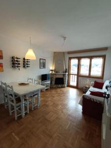 uma sala de estar com uma mesa e um sofá em [Prato Nevoso] Appartamento fronte conca em Prato Nevoso