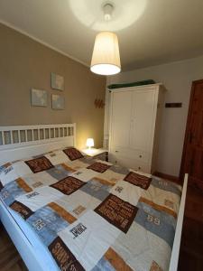 um quarto com uma cama com uma colcha em [Prato Nevoso] Appartamento fronte conca em Prato Nevoso