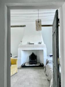 ein Wohnzimmer mit einem Kamin und einem Bett in der Unterkunft Casa Blanca, Acequias, Lecrin valley, Granada in Granada