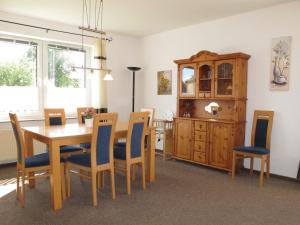 a dining room with a wooden table and chairs at Ferienhaus SONNE HORS100 in Wiarden