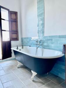 eine Badewanne im blauen Bad in der Unterkunft Casa Blanca, Acequias, Lecrin valley, Granada in Granada