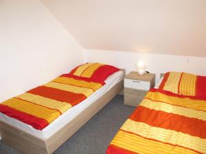 a bedroom with two beds and a table with a lamp at Ferienhaus SONNE HORS100 in Wiarden