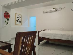 a bedroom with a bed and a fan on the wall at Rebel de Pondiche'ry in Pondicherry