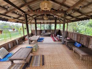 an outdoor pavilion with wooden benches and a table at i AM i Farm Stay in Mē Tamān