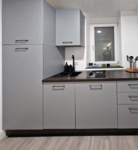 a kitchen with white cabinets and a black counter top at Space Suite Marina in Cagliari