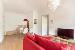 a living room with a red couch and a television at Dolomiti Relax in Feltre