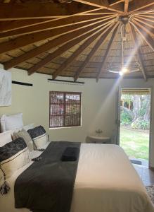 a bedroom with a large bed and a ceiling at Sgele Guesthouse & Events in Vryheid
