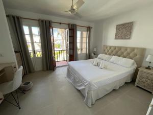 Schlafzimmer mit einem großen weißen Bett und Fenstern in der Unterkunft Villacana 2014 in Estepona
