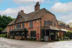 an old brick building with a sign on it at Bourne Valley Inn in Saint Mary Bourne