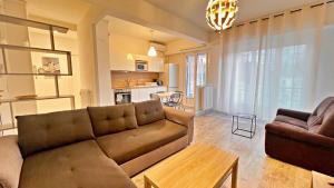 ein Wohnzimmer mit einem Sofa und einem Tisch in der Unterkunft Le Richemond - 50m de la MER in Nizza
