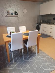 ヴァルチツェにあるUbytování nad sklípkemのキッチン(木製テーブル、白い椅子付)