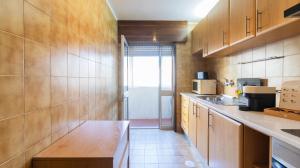 a kitchen with wooden cabinets and a counter top at Charmy Engenheiro António Costa Reis Apartment in Senhora da Hora