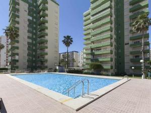 a swimming pool in front of two tall buildings at Olimpia playa gandia in Playa de Gandia