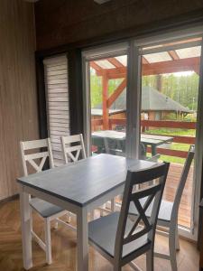 a white table and chairs in a room with a window at Agroturystyka Gajewo in Suchowola