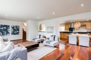 a living room with white furniture and a kitchen at Solana Beach Home 4 blocks from the Ocean in Solana Beach